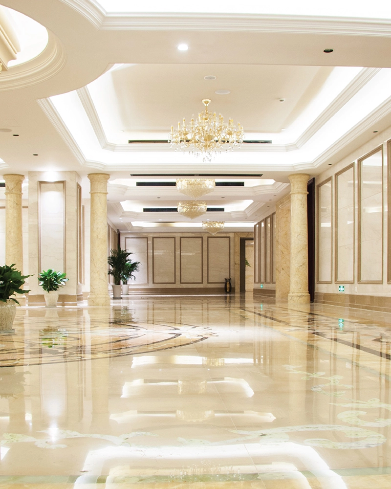 Double-height entrance lobby with chandeliers and polished stone floor
