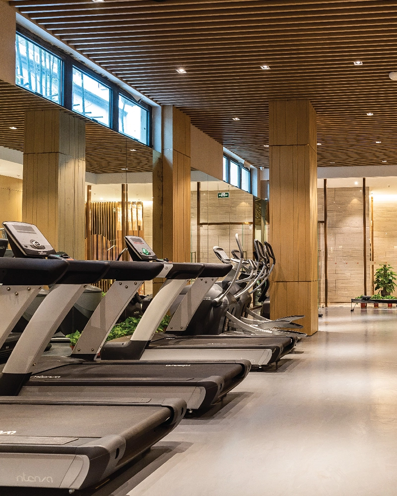 Gymnasium with cardio equipment along a glazed wall